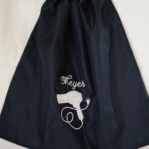 May include: Black drawstring bag with a white embroidered hairdryer and the name "Meyer" on the front.