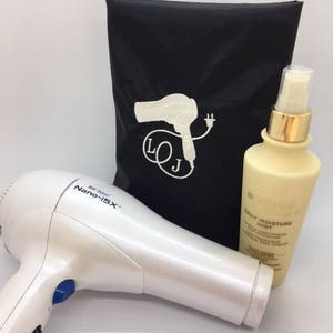 May include: A white hair dryer with a blue button and the text "Bio Ionic Nano-15X". A black travel bag with a white hairdryer and plug design and the text "LOJ". A clear bottle with a gold cap and the text "Daily Moisture Mist".