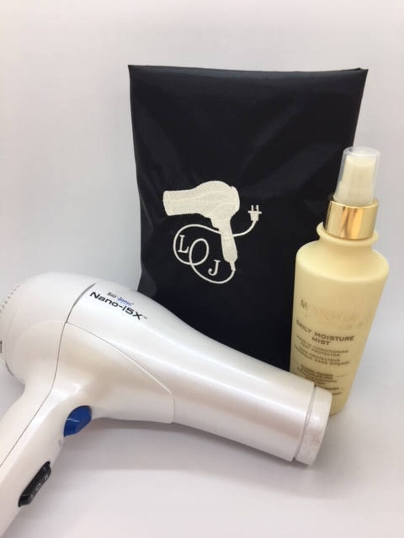 May include: A white hair dryer with a blue button and the text "Bio Ionic Nano-15X". A black travel bag with a white hairdryer and plug design and the text "LOJ". A clear bottle with a gold cap and the text "Daily Moisture Mist".