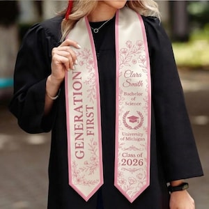 May include: A cream-coloured graduation sash with pink floral detailing and a pink border. The sash features the text "GENERATION FIRST" in maroon. The right side displays the name "Clara Smith", "Bachelor of Science", "University of Michigan", and "Class of 2026".