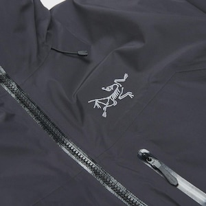 Puede incluir: Chaqueta con capucha gris oscuro con cremallera completa y un peque&ntilde;o logotipo blanco en el pecho. La chaqueta tiene un dise&ntilde;o elegante con cuello alto y capucha con cord&oacute;n. La cremallera es negra y tiene un dise&ntilde;o texturizado.