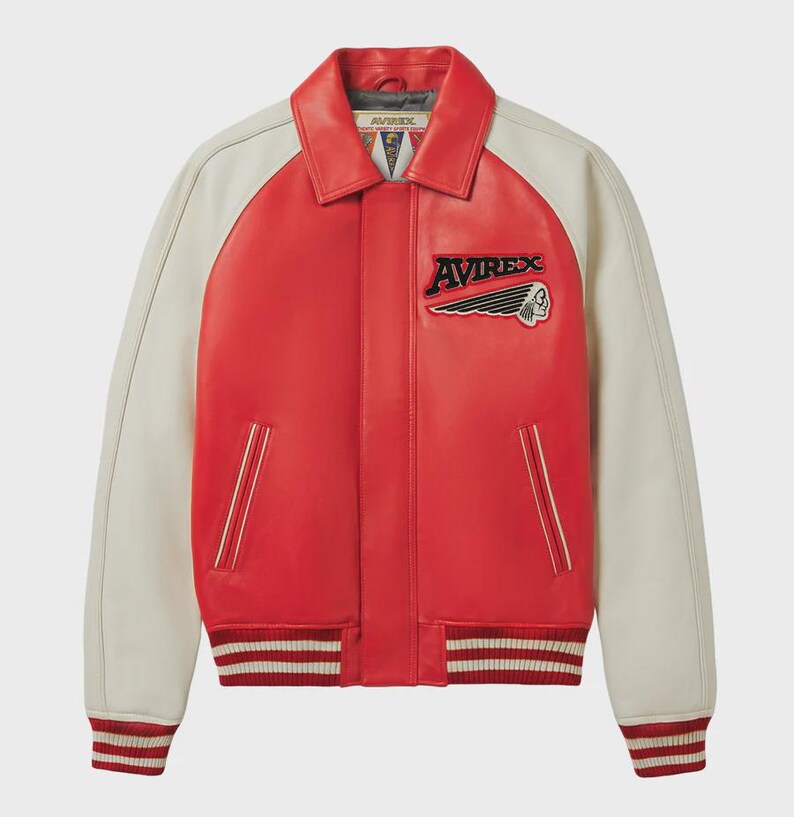 May include: Red and cream-colored leather jacket with the word "AVIREX" and a Native American head patch. The jacket has a collared neckline, cream-colored sleeves, and a striped hem and cuffs.