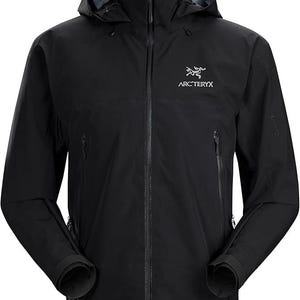 May include: Black hooded jacket with a full-length zipper and two side pockets. The jacket features the Arc'teryx logo on the chest. The jacket has a high collar and a hood for added protection from the elements. The sleeves have adjustable cuffs.