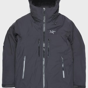 Puede incluir: Chaqueta con capucha gris oscuro con cremallera completa y m&uacute;ltiples bolsillos con cremallera. La chaqueta presenta un logotipo en el pecho y el nombre de la marca en la capucha. Dise&ntilde;ada para actividades al aire libre y clima fr&iacute;o.