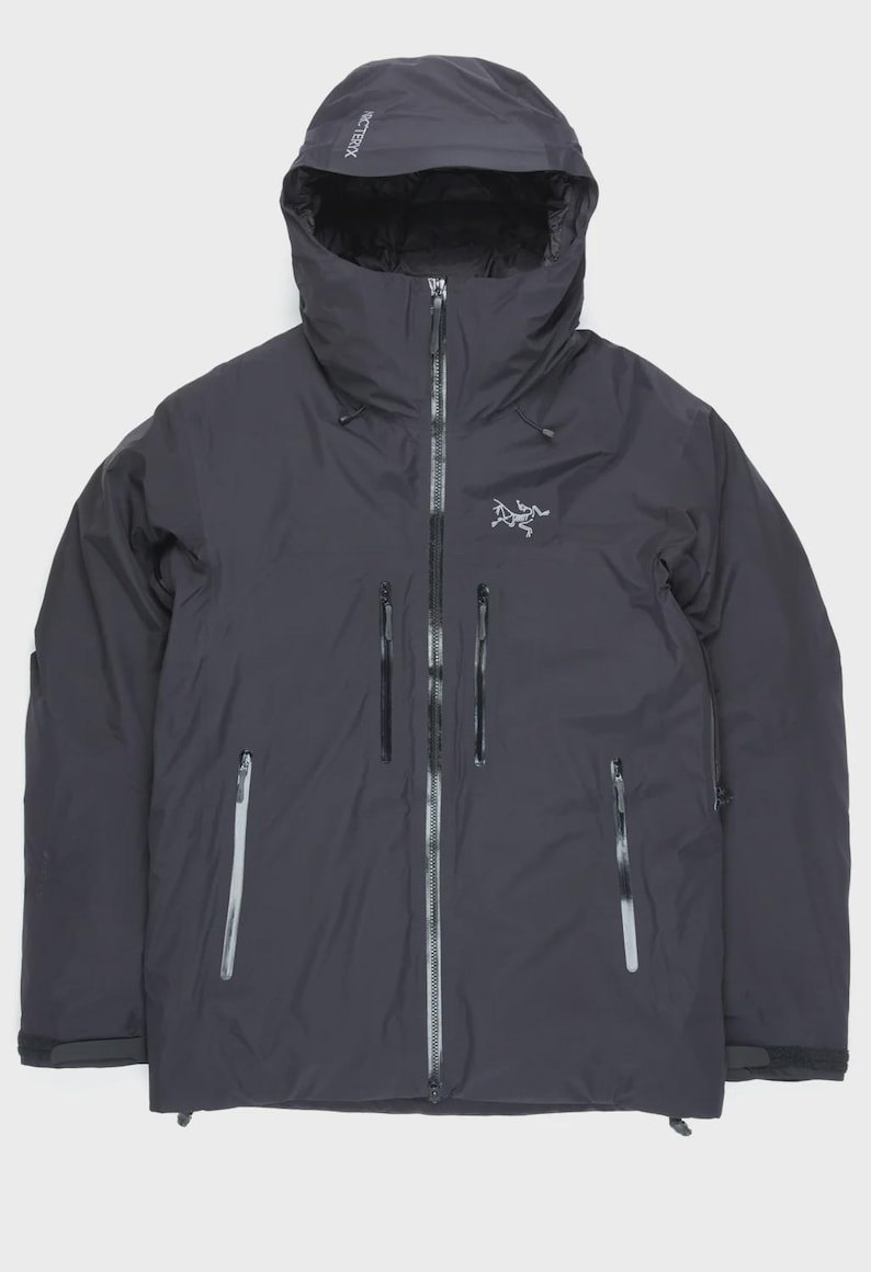 Puede incluir: Chaqueta con capucha gris oscuro con cremallera completa y m&uacute;ltiples bolsillos con cremallera. La chaqueta presenta un logotipo en el pecho y el nombre de la marca en la capucha. Dise&ntilde;ada para actividades al aire libre y clima fr&iacute;o.