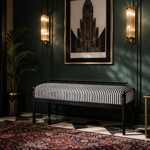 May include: A dark green entryway with a black and white striped bench, a framed architectural print, and a patterned rug. The room is decorated with a potted palm and a small side table. Wall sconces provide warm lighting.