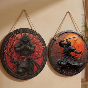 May include: Two round wall hangings featuring samurai warriors. One shows a samurai standing with crossed swords against a red background with cherry blossoms. The other depicts a samurai in action with a sword against an orange sun.