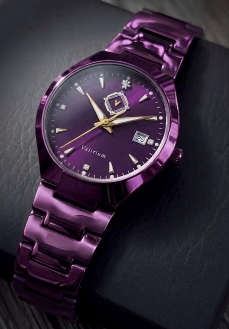 May include: A purple wristwatch with a matching band. The watch face is a deep purple with gold-colored hands and markers. The date is displayed at the 3 o'clock position. The watch is labeled "Valirium".