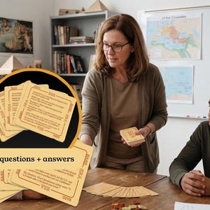 May include: A set of educational flashcards with the text "60 questions + answers" is displayed. The cards are tan with black text and are being used in a classroom setting. A teacher is holding a stack of cards, and students are seated at a table.