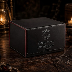 Könnte beinhalten: Eine rechteckige schwarze Aufbewahrungsbox mit magnetischem Deckel, roten Kantendetails und einem geprägten Logo mit dem Text "Your text or image" auf der Vorderseite. Die Box hat eine glatte, matte Oberfläche und ein strukturiertes Design.