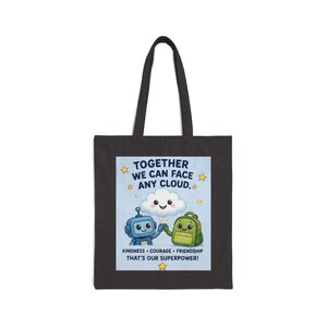 Peut inclure: Sac fourre-tout noir avec un graphisme coloré. Le graphisme représente un robot et un sac à dos se tenant la main avec un nuage souriant. Le texte dit "TOGETHER WE CAN FACE ANY CLOUD." En dessous, il est écrit "KINDNESS COURAGE FRIENDSHIP THAT'S OUR SUPERPOWER!"