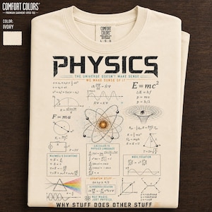 May include: Ivory-colored Comfort Colors t-shirt with a graphic design featuring the word "PHYSICS" and various scientific equations and diagrams. The shirt includes the text "WHY STUFF DOES OTHER STUFF".
