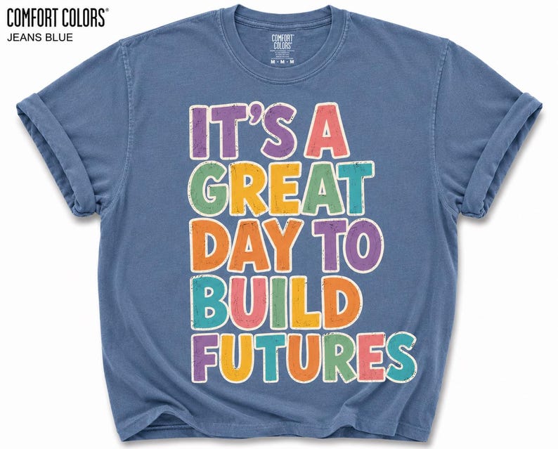 May include: Jeans blue t-shirt with the text "IT'S A GREAT DAY TO BUILD FUTURES" in colorful letters. The shirt is from Comfort Colors.
