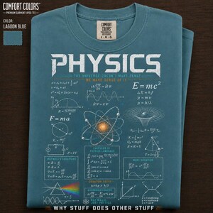 Puede incluir: Camiseta Comfort Colors azul laguna con la palabra "PHYSICS" en letras blancas grandes. La camiseta presenta ecuaciones científicas, diagramas y la frase "WHY STUFF DOES OTHER STUFF". Talla L-G.