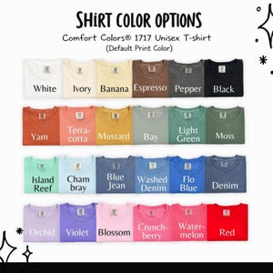 May include: A display of Comfort Colors 1717 unisex t-shirts in various colors. The image shows a range of hues, including white, ivory, banana, espresso, pepper, black, yam, terracotta, mustard, bay, light green, moss, island reef, chambray, blue jean, washed denim, flo blue, denim, orchid, violet, blossom, crunchberry, watermelon, and red.