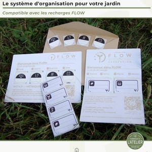 Peut inclure: Un ensemble de système d'organisation de jardin comprenant 120 étiquettes, des autocollants rectangulaires blancs avec des icônes noires, des cartes d'instructions avec le texte Inkbeam Flow Gardenflow et une enveloppe brune pour le jardinage.