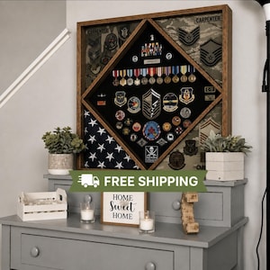 May include: A square wooden shadow box display case featuring a diamond-shaped black velvet interior. The case contains various military medals, ribbons, and patches, including the name Carpenter. A folded American flag is visible in the corner.