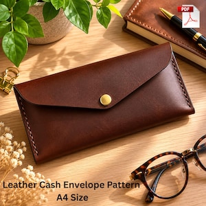 Peut inclure: Une enveloppe en cuir marron avec une fermeture à bouton doré. L'enveloppe est rectangulaire avec un rabat. Le texte "Leather Cash Envelope Pattern A4 Size" est au bas de l'image.