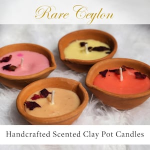 以下が含まれることがあります： ピンク、黄色、オレンジ、ベージュの4色の手作りの香りのクレイポットキャンドル。各キャンドルには白い芯があり、ドライフラワーの花びらで飾られています。「Rare Ceylon」と「Handcrafted Scented Clay Pot Candles」の文字が見えます。