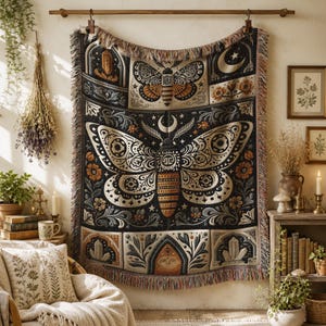 May include: A decorative tapestry featuring a large moth design with intricate patterns in cream, black, and orange. The tapestry has a fringed edge and is hung on a wooden rod. The design includes floral and celestial elements.