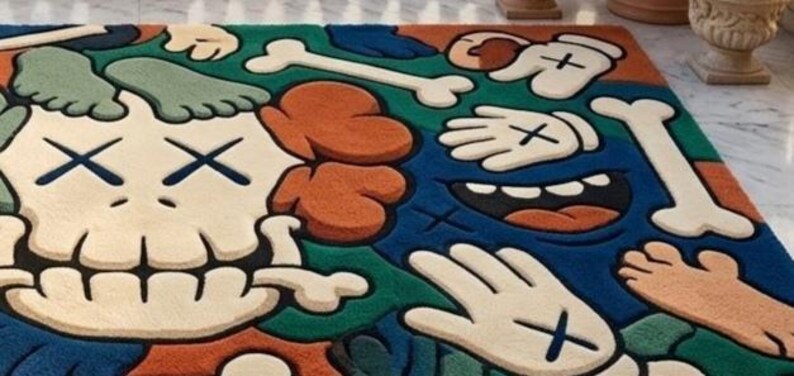 May include: A colorful rug featuring a cartoon-style design with a skull, bones, hands, and feet. The rug has a blue, green, orange, and off-white color scheme. The design includes cross-shaped eyes and hand details.