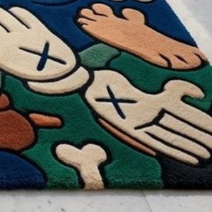 May include: A colorful, cartoon-style rug featuring a playful design. The rug showcases a variety of shapes, including hands, feet, and bones, with a bold color palette of blue, green, beige, brown, and black. The rug is a unique decorative item.