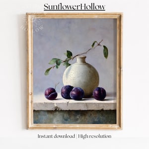 May include: A framed still life painting featuring a white vase with a cracked texture, a sprig of leaves, and several dark purple plums. The painting has a soft, muted color palette and the text "SunflowerHollow" is at the top.
