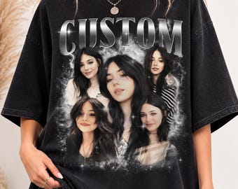 May include: A black acid-wash t-shirt featuring the word CUSTOM in a metallic silver font at the top. Below the text is a collage of five portraits of the same person with long dark hair, surrounded by a glowing white ethereal light effect.