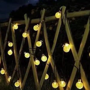 May include: A white ceramic mug with a black handle and the text "But First, Coffee" in a bold, black font. The mug is sitting on a wooden surface. The mug is approximately 4 inches tall.