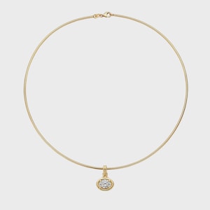 Könnte beinhalten: Eine goldene Omega-Kettenhalskette mit einem einzelnen ovalen Anhänger. Der Anhänger ist mit einem klaren, facettierten Stein besetzt, der von vier Krappen gehalten wird. Die Kette hat einen sicheren Verschluss oben und bildet eine kreisförmige Silhouette.