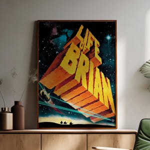 May include: A framed poster with the words "LIFE OF BRIAN" in large, yellow, 3D block letters. The background features a space scene with stars, planets, and a spaceship. The bottom of the poster shows three silhouettes of people.