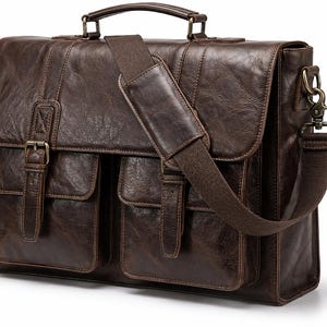 May include: A brown leather briefcase with a top handle, two front pockets, and a shoulder strap. The bag has a flap closure with buckles and metal hardware. The leather has a distressed appearance.