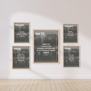 May include: Five framed workout posters with black text on a gray background. The posters are in wooden frames and are hanging on a white wall. The posters list workout routines for Michael, Angie, Nate, Chelsea, and Fran.