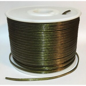 May include: A spool of olive green wire, tightly wound on a white plastic reel. The wire has a metallic sheen, reflecting light. The spool is sitting on a white surface.