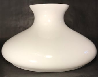 Puede incluir: Una pantalla de lámpara de vidrio blanco opaco con un cuerpo redondeado y un cuello acampanado. La pantalla tiene un acabado liso y brillante. El diseño general recuerda a un diseño vintage clásico.