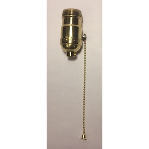 May include: A brass-colored lamp socket with a pull chain. The socket has a threaded top and a cylindrical body. The pull chain is made of small, round, gold-colored beads and ends in a decorative bell.