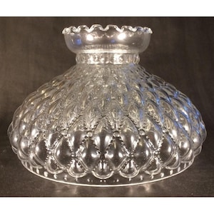 May include: A clear glass lamp shade featuring a textured diamond pattern across its dome-shaped body. The shade has a ruffled top edge and a wide, circular base with a subtle beaded border detail, designed for light diffusion in a lamp fixture.