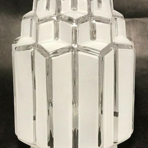 May include: A white ceramic mug with a black handle and the text "But First, Coffee" in a black, handwritten-style font. The mug is on a white surface.