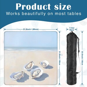May include: A square mat featuring a beach scene with four oyster shells on the sand, measuring 31.5 inches by 31.5 inches. It includes a black cylindrical carrying bag with a shoulder strap, measuring 7.1 inches wide and 33.5 inches in height.
