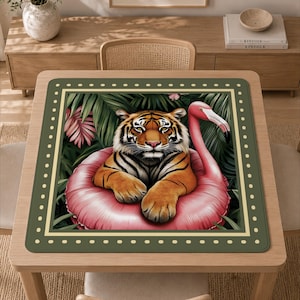 Peut inclure: Un tapis carré présentant une illustration centrale d'un tigre orange et noir reposant dans une bouée rose en forme de flamant rose. La scène est sur un fond de feuilles tropicales vert foncé, encadrée par une bordure vert foncé à pois crème.