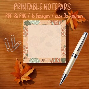 Puede incluir: Un bloc de notas cuadrado con un patrón repetitivo de calabazas y hojas en tonos naranja, verde y crema. El texto PRINTABLE NOTEPADS PDF & PNG / 6 Designs / size 3x3inches es visible en la parte superior. Tres clips plateados y un bolígrafo están presentes.