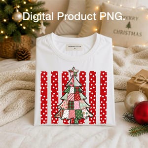 May include: A white t-shirt featuring a graphic of a patchwork-style Christmas tree centered over a background of vertical red stripes with white polka dots. The shirt has a crew neckline and a label inside the collar that reads Premium Cotton M.