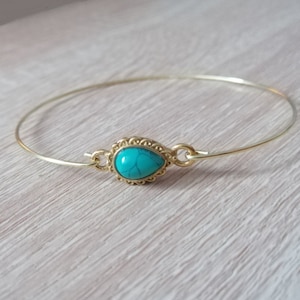 Peut inclure: Un bracelet jonc en or avec une pierre turquoise en forme de larme sertie dans un décor en filigrane doré.