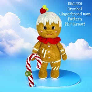 Peut inclure: Poupée en crochet représentant un bonhomme en pain d'épices, avec un nœud papillon rouge et une canne en bonbon. La poupée a du glaçage blanc sur la tête avec des vermicelles et une fraise rouge. Le texte "ENGLISH Crochet Gingerbread man Pattern PDF format" est inclus.