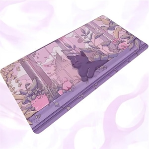 Peut inclure: Un tapis de bureau rectangulaire présentant une illustration dans les tons violets d'un chat foncé se reposant sur un rebord de fenêtre. La scène comprend des plantes en pot, un petit oiseau rose et une vue par la fenêtre avec des décorations.