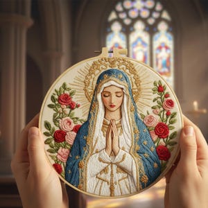 May include: A circular embroidery featuring a religious figure with a blue veil and gold halo, encircled by red and pink roses. The artwork is displayed in a wooden hoop, highlighting intricate stitching. The background is blurred, implying a church interior.