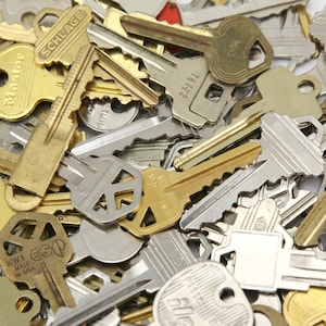 A mix of silver and yellow brass keys. They are in used condition and consist of cut and uncut keys. Types of keys can include, house, file cabinet, padlock, door, car, equipment, and more.  They are great for crafting, and mixed media art projects.