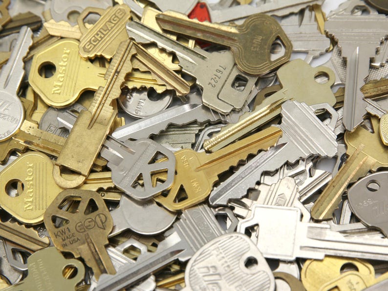 A mix of silver and yellow brass keys. They are in used condition and consist of cut and uncut keys. Types of keys can include, house, file cabinet, padlock, door, car, equipment, and more.  They are great for crafting, and mixed media art projects.