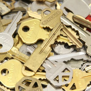 A mix of silver and yellow brass keys. They are in used condition and consist of cut and uncut keys. Types of keys can include, house, file cabinet, padlock, door, car, equipment, and more.  They are great for crafting, and mixed media art projects.