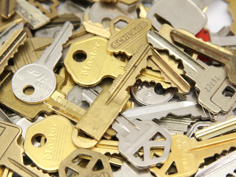 A mix of silver and yellow brass keys. They are in used condition and consist of cut and uncut keys. Types of keys can include, house, file cabinet, padlock, door, car, equipment, and more.  They are great for crafting, and mixed media art projects.